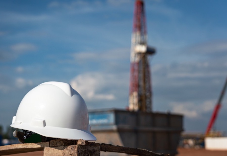 Schutzhelm auf einer Baustelle mit Kran im Hintergrund